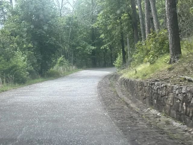 Curving mountain drive beside a stone retaining wall in Hot Springs National Park